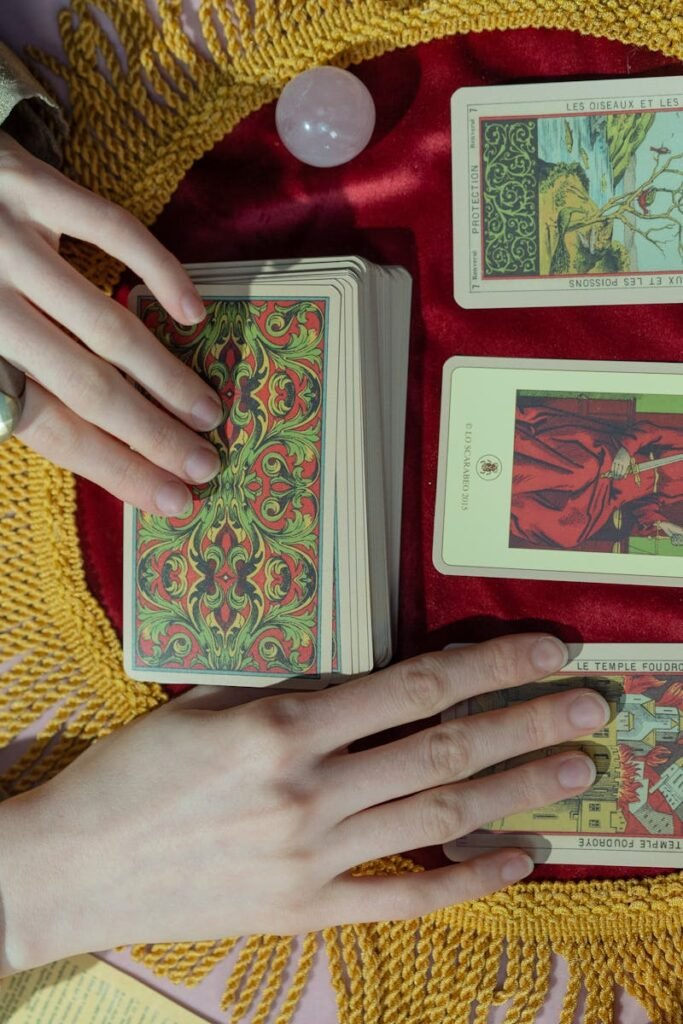 A close-up view of a tarot reading featuring a crystal ball and vibrant tarot cards on a colorful spread.